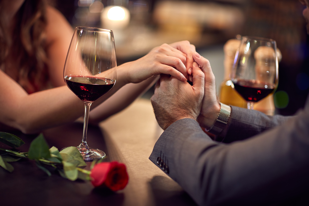 couple holding hands at a table